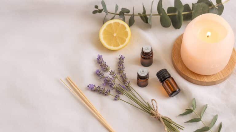 Essential Oils 101 beginner guide with essential oil bottles, diffuser, lavender, lemon, and eucalyptus in a soft, feminine flat lay